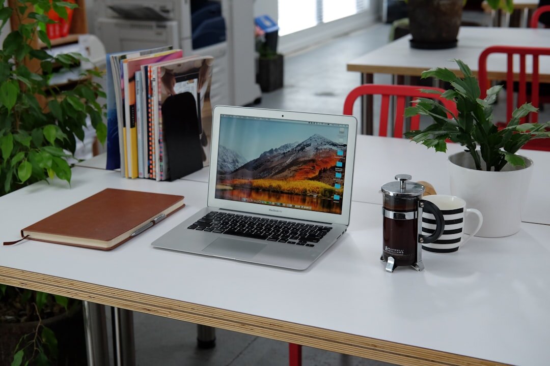 Laptop on a desk with journalism tools and notebooks